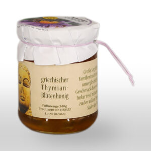 Ein Glas mit griechischem Thymianblütenhonig mit weißem Papierdeckel, Schnur und einem Etikett mit einem Buddha-Bild und deutschem Text.